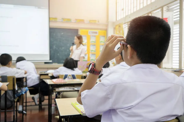 Teacher lectures in front of class. Students wear uniforms. — Stock Photo, Image