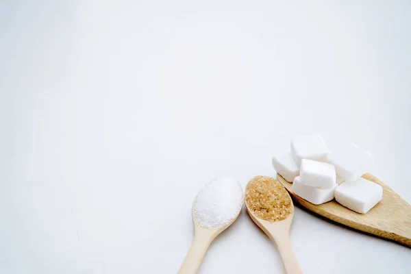 Sucre blanc, cassonade, cubes de sucre, placés dans une cuillère en bois. — Photo