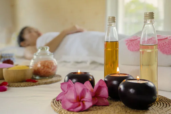 Aceites de aromaterapia colocados junto a una toalla blanca y flores. —  Fotos de Stock