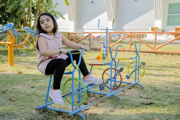 An Asian girl is playing on a playground. — Stock Photo, Image