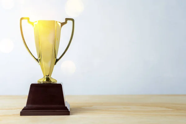 Gold trophy placed at work desk — Stock Photo, Image