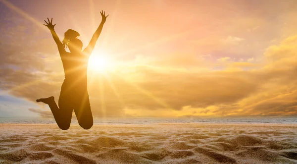 少女はビーチで楽しいと一緒にジャンプしている 夕方には黄金の太陽と海 夏のコンセプト — ストック写真