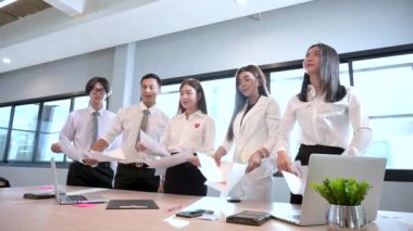 Bir grup iş adamı iş belgesini atmaktan memnuniyet duyar.