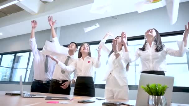 Egy csapat üzletember boldogan eldobja a munkadokumentumot. — Stock videók