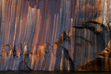 Superior Gölü 'nün aşınmış kumtaşı kıyı şeridi boyunca uzanan mineral lekeli uçurum manzarası, Resimli Kayalar Ulusal Lakeshore, Michigans Yukarı Yarımadası, ABD