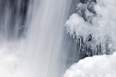 Buz çerçeveli kış şelalesinin manzarası ve hareket bulanıklığı ile yakalanan Comstock Creek Cascade, Michigan, ABD