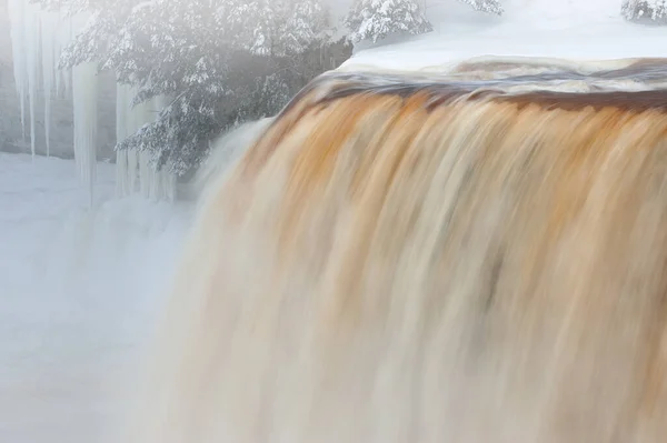 美国密歇根州上半岛 塔卡迈农瀑布上空多雾的冬季风景被运动的模糊所捕捉 被冰柱和针叶树构成了框架 — 图库照片
