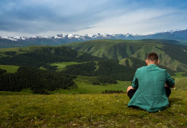 旅行者は丘の端に座って 山の自然を楽しむ — ストック写真