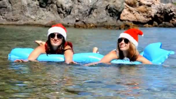 Güzel genç kadın Noel şapka ile denizde yüzüyor — Stok video
