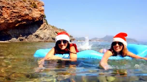 年轻漂亮的女性都戴着圣诞帽子海中游泳 — 图库视频影像