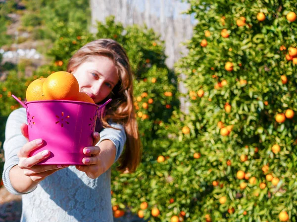 Flicka med apelsiner i trädgården — Stockfoto