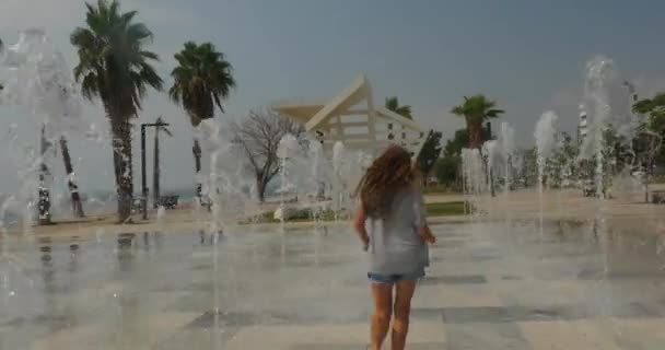 Giovane ragazza si diverte nella fontana del parco cittadino — Video Stock