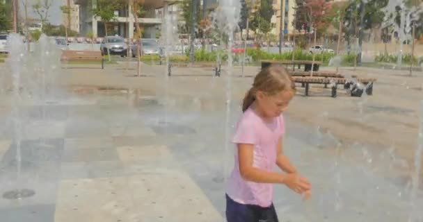 Ung flicka som har kul i stadsparken fontän — Stockvideo