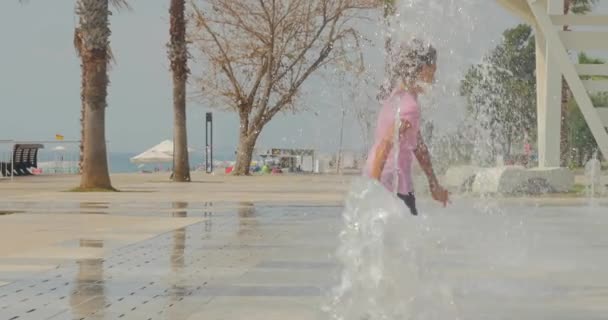 Chica joven divirtiéndose en la fuente del parque de la ciudad — Vídeo de stock