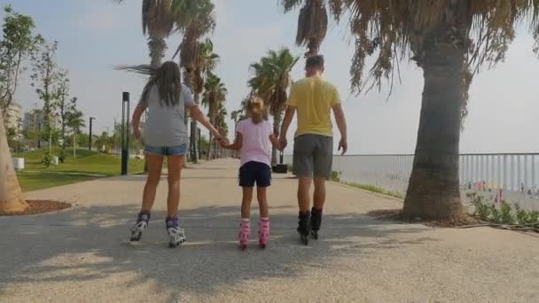 Отец с дочерьми катается на роликах — стоковое видео