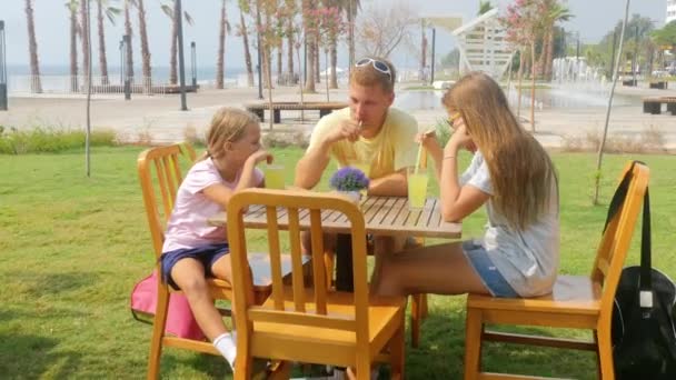 Familie babbelen en limonade drinken buiten — Stockvideo