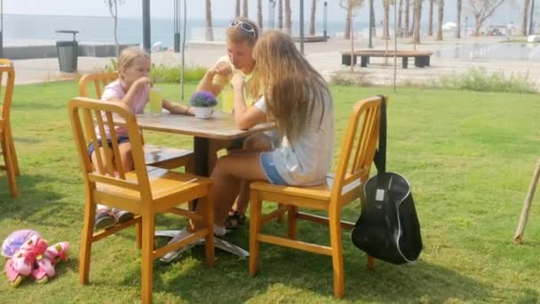 Family chatting and drinking lemonade outdoors — 비디오