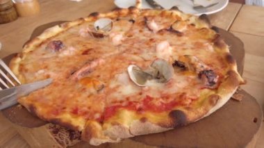Kafede pizza yiyen arkadaşlar Tahta tahtadan dilimler alıyorlar