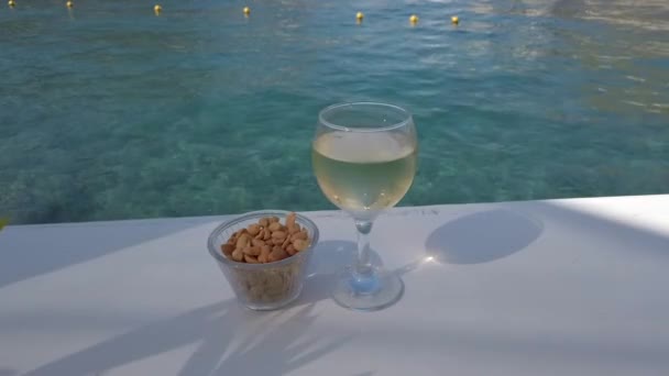 Glass of white wine on the table near sea — Stock Video