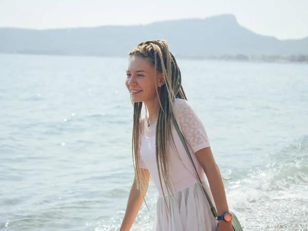 海のそばを歩くドレッドロックを持つ若い女性 — ストック写真