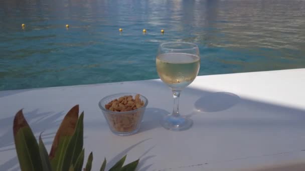 Glass of white wine on the table near sea — 비디오