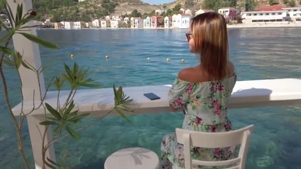 Jeune femme assise calmement au bord de l'eau — Video