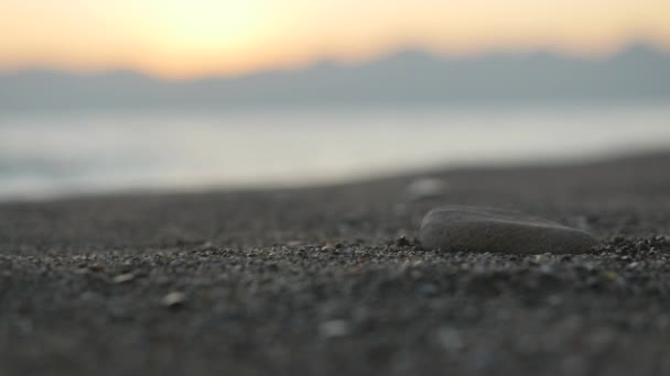 Het maken van stenen toren op zee strand bij zonsondergang. — Stockvideo