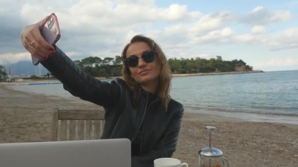 Mujer joven tomando selfie en café al aire libre — Vídeos de Stock