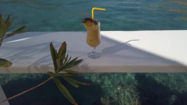 Deniz kenarındaki masada taze ananas suyu var.