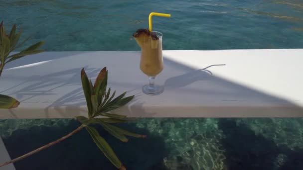 Свежий анановый сок на столе возле моря — стоковое видео