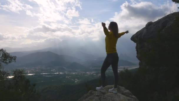 Молода жінка стоїть на кінці скелі — стокове відео