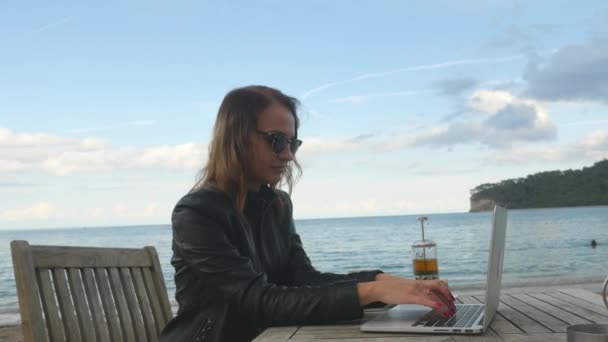 Young woman fast typing on laptop in outdoor cafe — Αρχείο Βίντεο