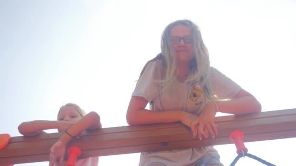 Two sisters playing on a climbing frames — ストック動画