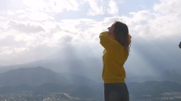 Young woman standing on the end of the cliff — Wideo stockowe