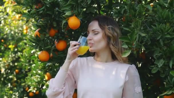 Mujer joven bebiendo jugo de naranja — Vídeo de stock