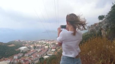 Kadın gezgin akıllı telefonuyla fotoğraf çekiyor.