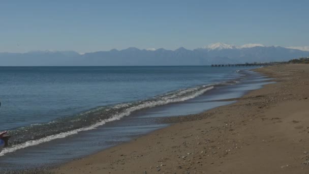 Young boy running along the sea — Stock Video