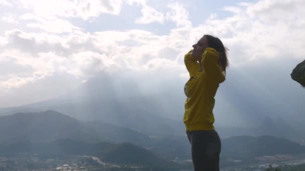 Young woman standing on the end of the cliff — Αρχείο Βίντεο