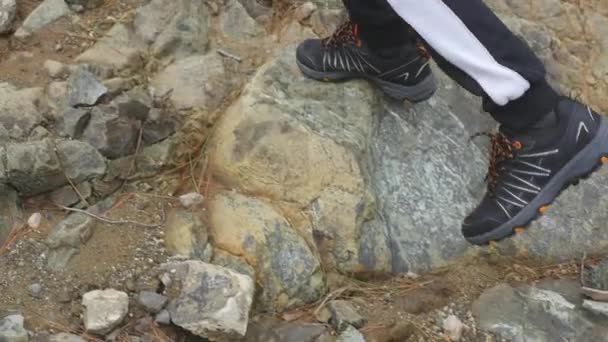 Niño en zapatillas de deporte caminando sobre piedras — Vídeos de Stock