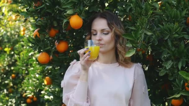 Mujer joven bebiendo jugo de naranja — Vídeos de Stock