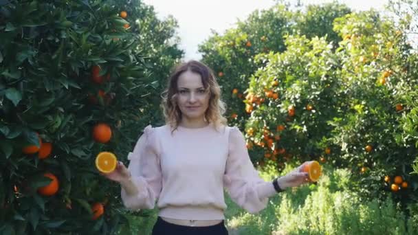 Giovane bella donna che tiene le arance davanti ai suoi occhi — Video Stock