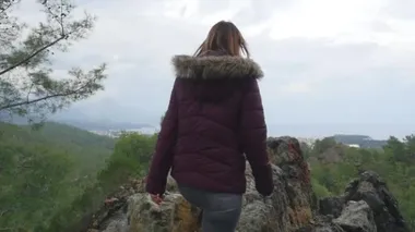Genç bayan uçurumun sonunda el kaldırıyor.