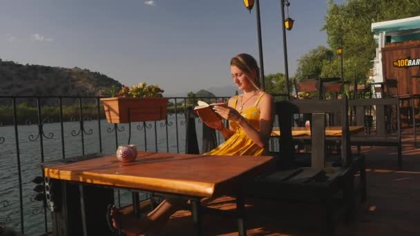 Kvinna med anteckningsbok nära floden — Stockvideo