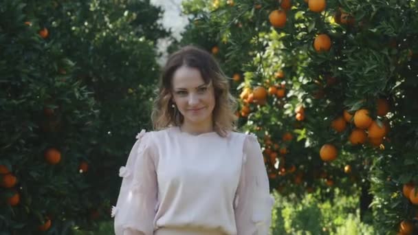 Jovem mulher bonita segurando laranjas na frente de seus olhos — Vídeo de Stock