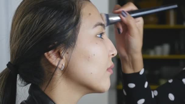 Professionell make-up artist tillämpa pulver på modell ansikte — Stockvideo