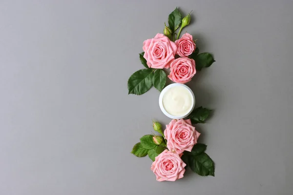 a care cream in a jar on a pastel background with beautiful roses. anti-aging cream. Cream for skin care. for hands. for face. cosmetics for care.