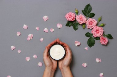 krem ve kadın elleri pastel bir arka plan üzerinde. çiçek, bir bakım kremleri ve eller bileşimi. minimalizm. Anti-Aging Krem. Cilt Bakımı. duygusuzca