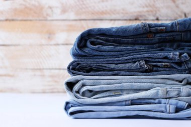 Mükemmel bir yığın farklı renklerde hafif bir arka plan üzerinde kot pantolon. minimalizm, tasarım,