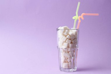 Saydam bir cam metin için yer pastel bir zemin üzerine şeker dolu. küp şeker. Minimalizm, diyabet, kalori, tatlı içecekler. 