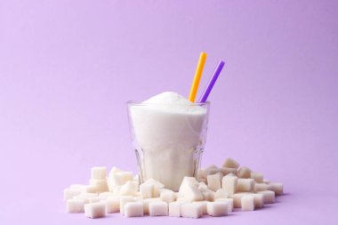 Saydam bir cam metin için yer pastel bir zemin üzerine şeker dolu. küp şeker. Minimalizm, diyabet, kalori, tatlı içecekler. 